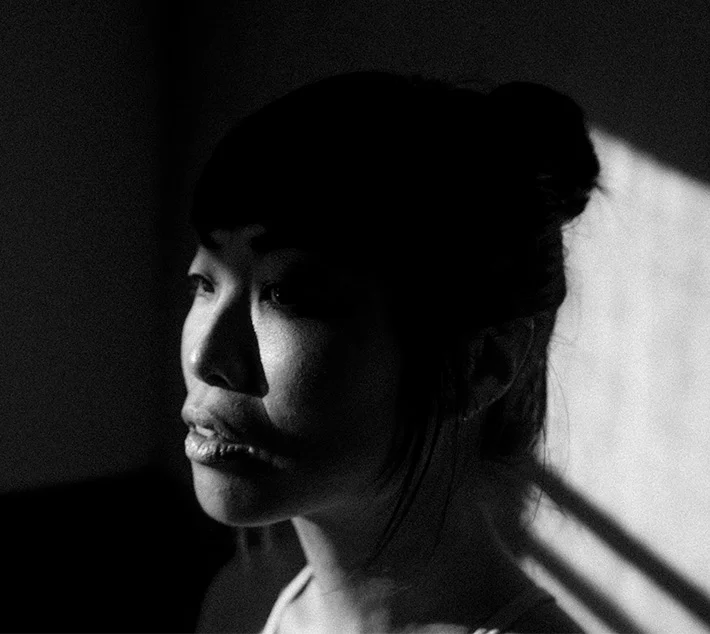 A close-up of a woman's profile, illuminated by soft light and shadows, creating a dramatic black-and-white effect. - MOHS Reconstruction in West Village, New York, NY